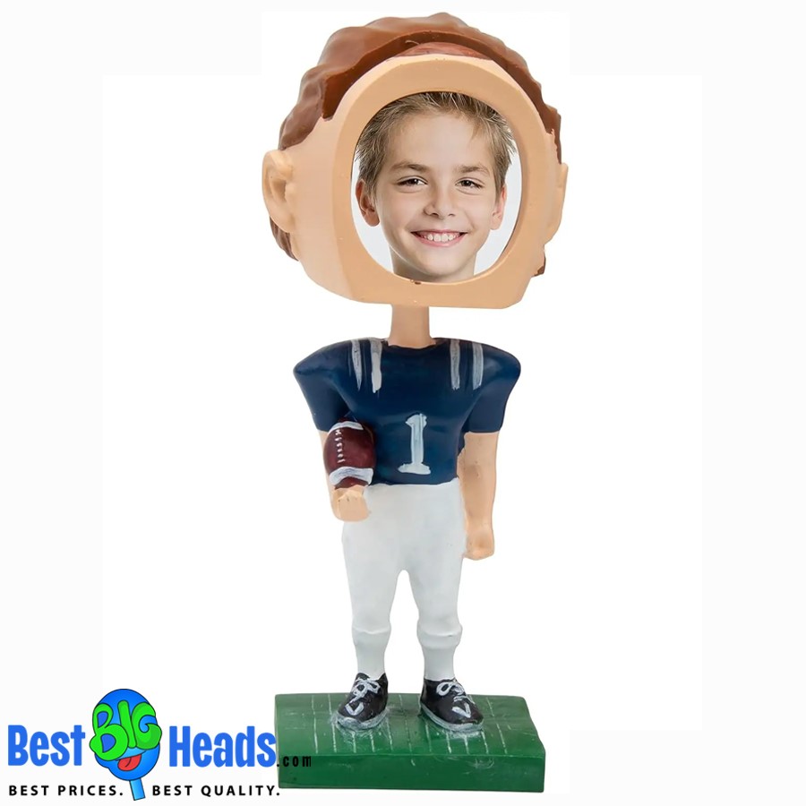 A custom bobblehead of a young boy dressed as a football player, holding a football and wearing a blue jersey with the number 1. The bobblehead features an oversized head with a cutout for a personalized photo.