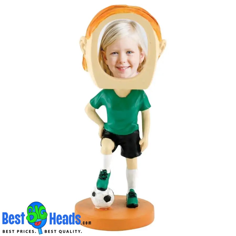 A custom bobblehead of a young girl in a soccer uniform, with one foot on a soccer ball. The figurine features an oversized head with a cutout for a personalized photo.